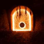 Harvey Miller - A spinning wheel of sparks fly out from circle in the mouth of a tunnel.