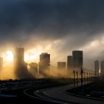 Housam Yeung - Sunlight streams through dark clouds and high rise buildings.