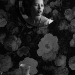 Isabella Wilson - Black and white image of a girl's reflection in a mirror, on a flowery wall.