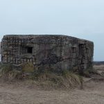 Taylor William Dixon Berry - Image of a weathered old concrete military pillbox on a beach, taken on a cloudy day.