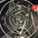 Amy Garner - Forks, cutlery and kitchen utensils in a metal basket