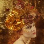 Evelyn Baldry - Portrait, side profile of a person with an ornate gold headdress on. Background is gold